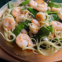 shrimp with pea pods served in an orange serving bowl