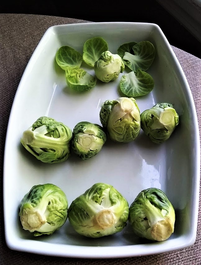 rows of brussels sprouts showing stages of trimming