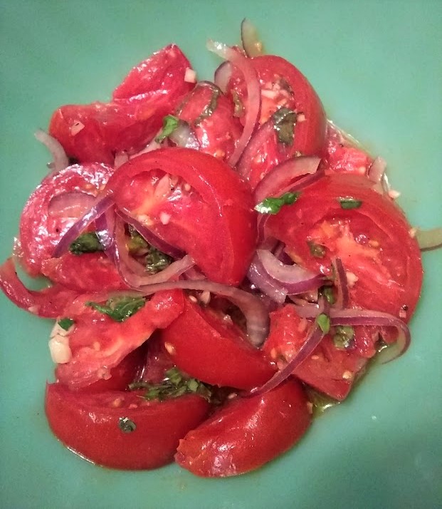 tomato salad ready to serve in a green bowl