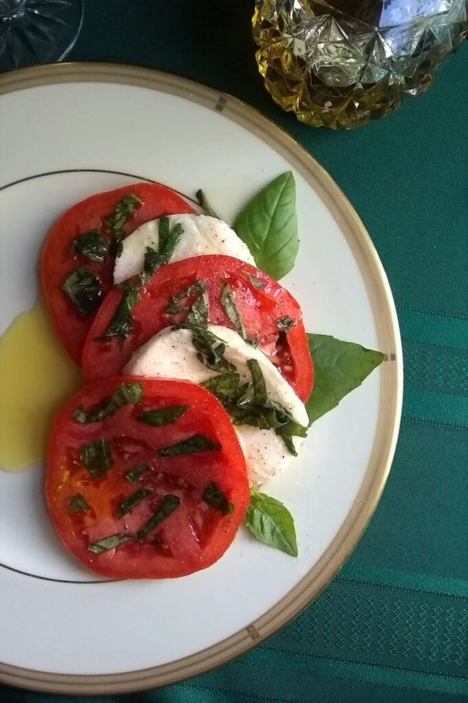 caprese salad served on ivory and gold plate