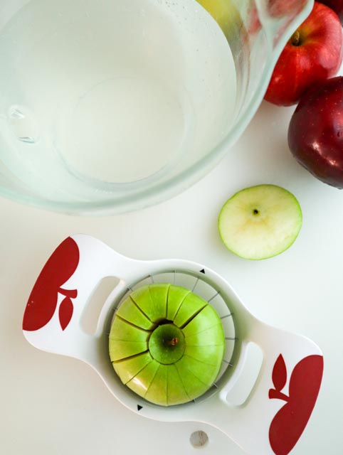 cold water with lemon juice and an apple on an apple corer