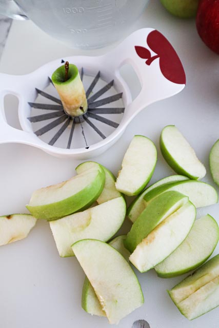 apple corer and apple slices with their peel still on