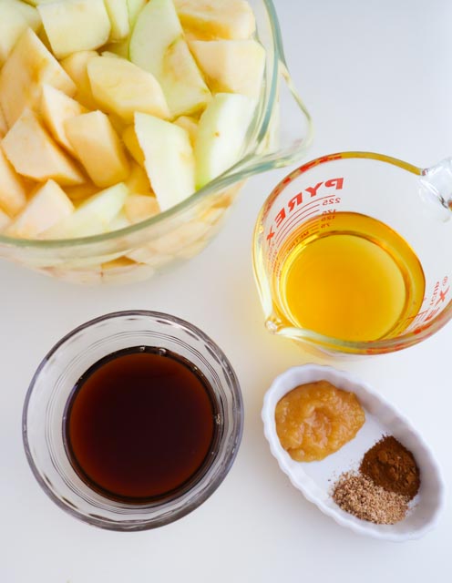 ingredients for homemade applesauce apple juice maple syrup fresh ginger cinnamon nutmeg and sliced apples