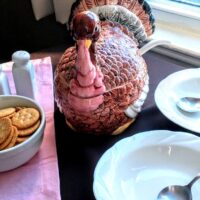 turkey soup tureen on table with bowls and crackers