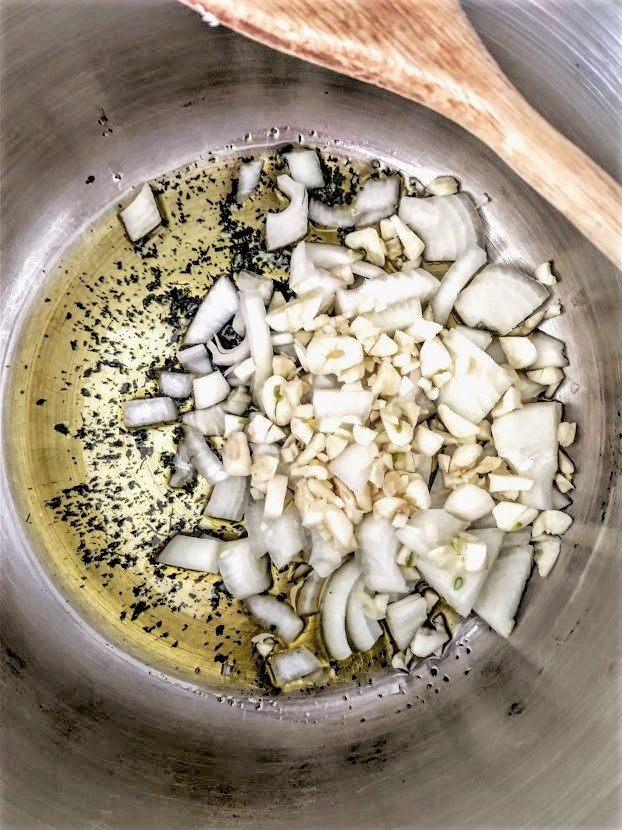 pasta fagioli soup olive oil garlic  onion and basil on the stove in a large pan