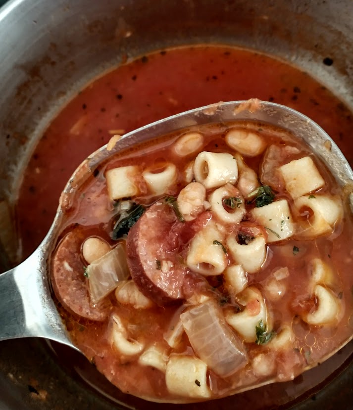 pasta fagioli soup done and being ladled out of the large pot after the pasta is added