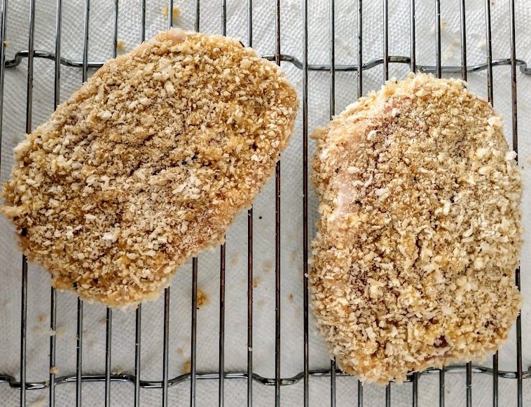 breaded pork filets uncooked with flour and crumb coating on a baking rack