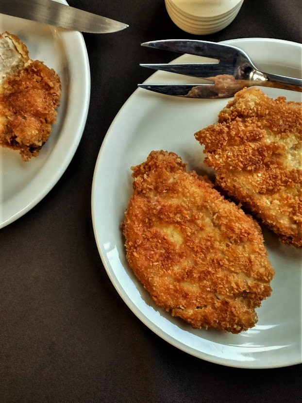 golden brown fried pork cutlets with a crispy crunchy crust on a serving dish