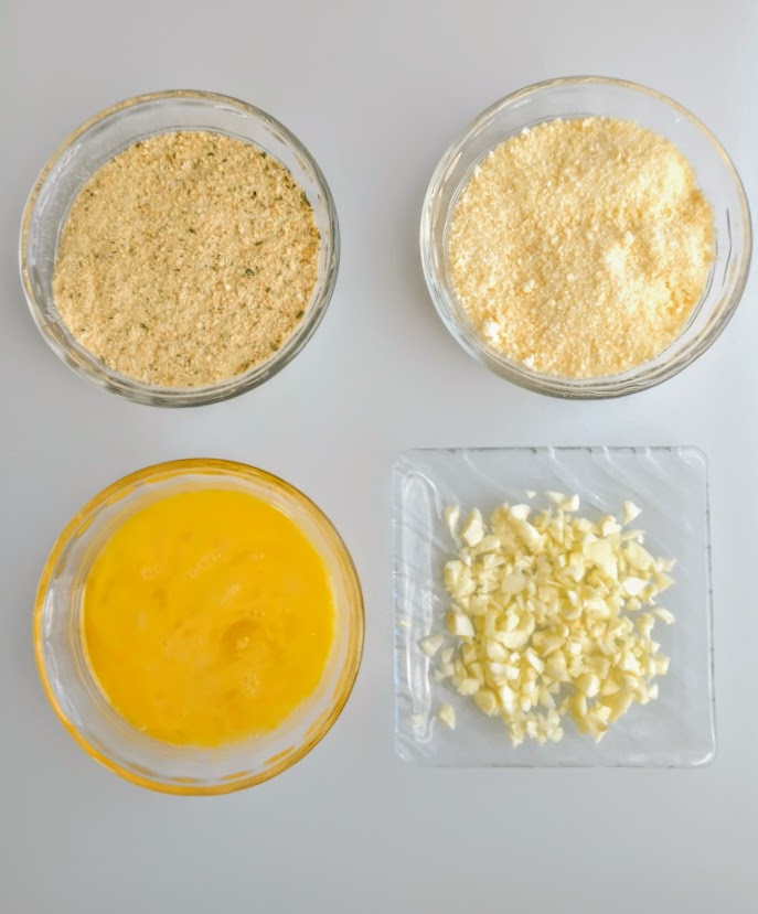 ingredients ready to  make stuffing beaten egg minced garlic grated cheese and breadcrumbs