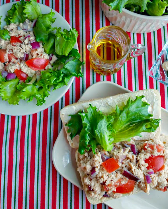 italian tuna salad in a sandwich and a salad with olive oil and mayo on the side