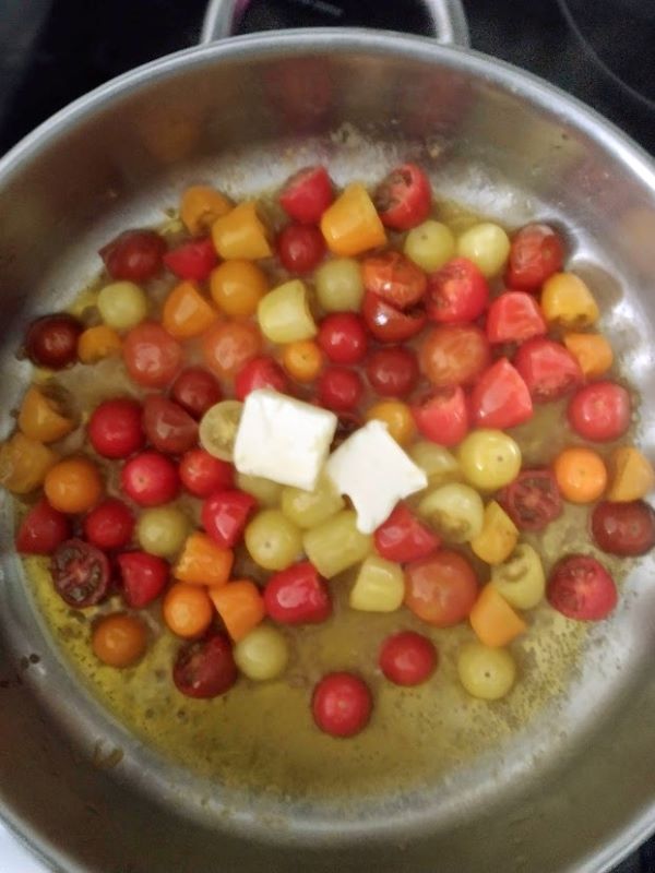 kids meal colored grape tomatoes in olive oil in skillet with butter melting on top