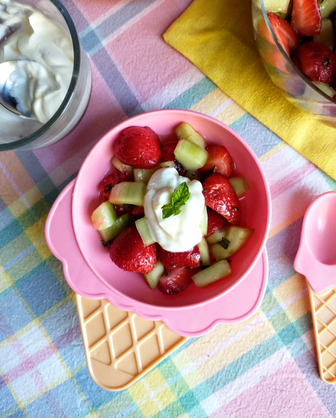 kids salad with strawberries and cucumber with a dollop of sour cream and honey topping served in kids dish