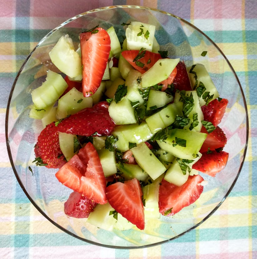 bowl of mixed ingredients for kids salad and dieters dessert strawberries cucumbers mint and honey