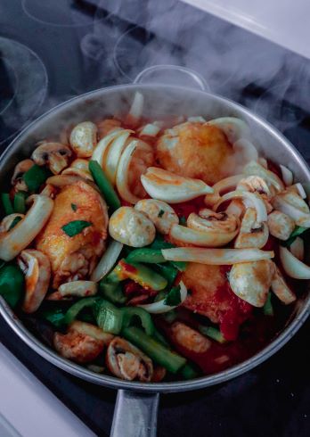 stirring ingredients together for chicken cacciatore