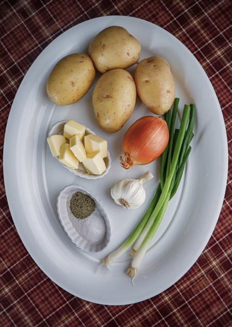 ingredients for potato and onion casserole potatoes onion garlic butter salt and pepper and scallions 