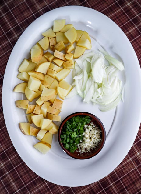 chopped potatoes sliced onions and chopped scallions and garlic