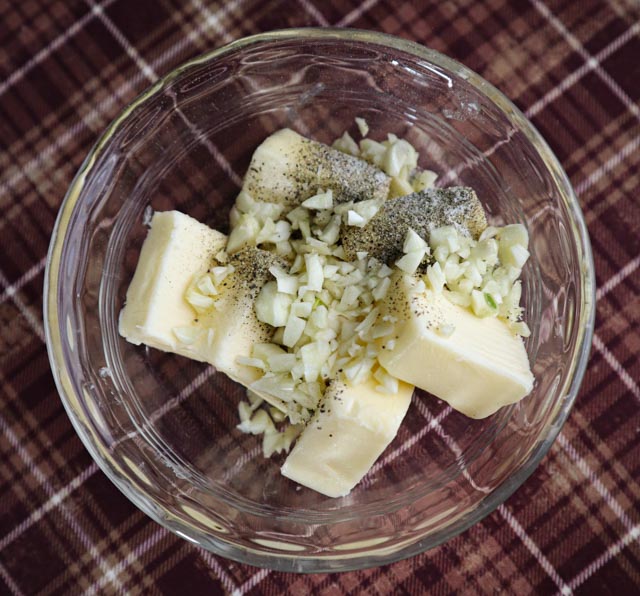 butter salt pepper and garlic in a microwave safe cup ready to be melted 