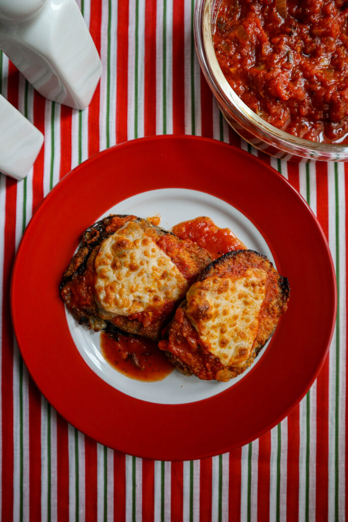 sliced eggplant with marinara sauce and melted parmesan cheese