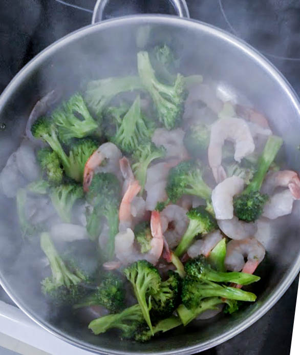 shrimp cooking in hot skillet with steam rising