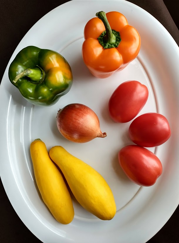 ingredients for emmas roasted vegetables for pasta roma tomatoes orange and green pepper onion and yellow summer squash