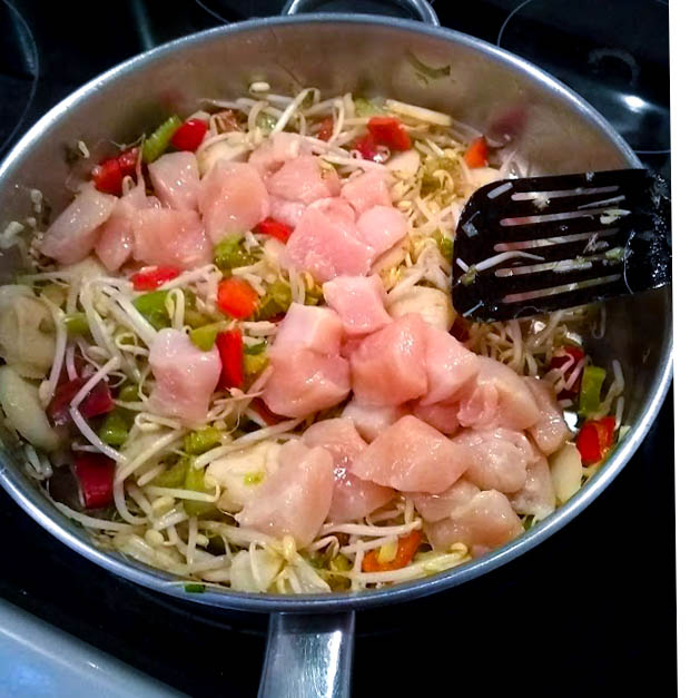 chopped chicken added to the sautéed vegetables in skillet 