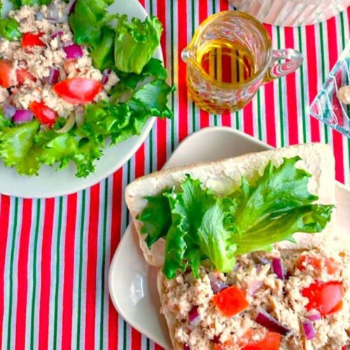 italian tuna salad in a sandwich and a salad with olive oil and mayo on the side