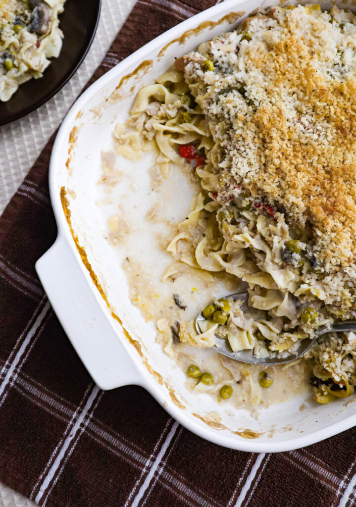 tuna noodle casserole served in a baking dish with some already spooned out