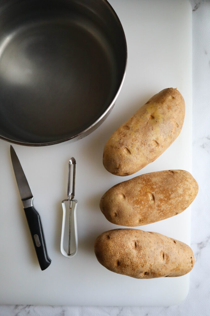 3 russet potatoes a paring knife and a vegetable peeler