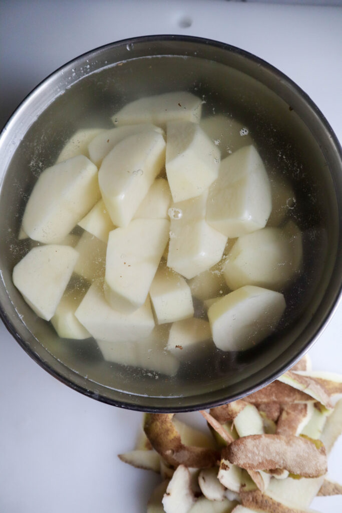 just peeled and cut potatoes in cold salted water