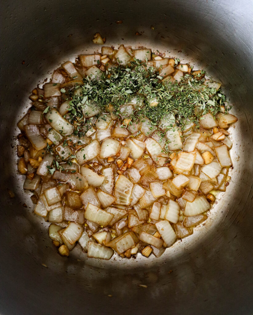 add thyme and oregano to the sauteed onion and garlic