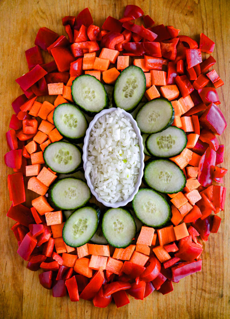 a cutting board with a variety of colorful vegetables that have been minced sliced diced and chopped