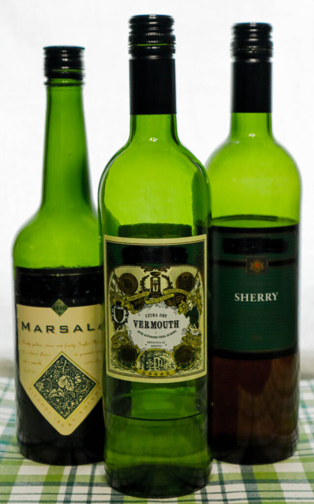 a bottle of vermouth a bottle of marsala and a bottle of sherry all used for cooking