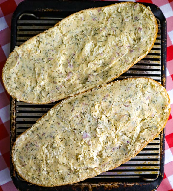 two halves of italian bread with garlic butter spread on them