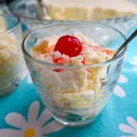 pineapple cream dessert served in a glass with a cherry on top