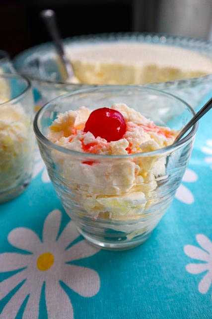 pineapple cream dessert served in a glass with a cherry on top