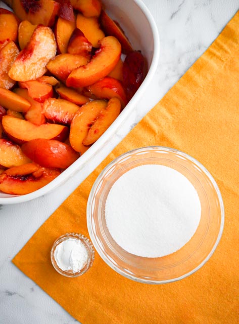 slices of nectarine and glass bowls with sugar and corn starch