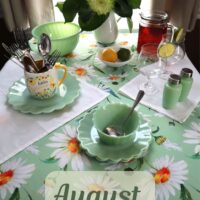 august dinner table big white daisies on light green tablecloth with light green dishes and light green flowers