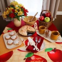 september dinner table setting with apples and cinnamon red and gold