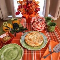 dinner table setting for october in orange and green with spider