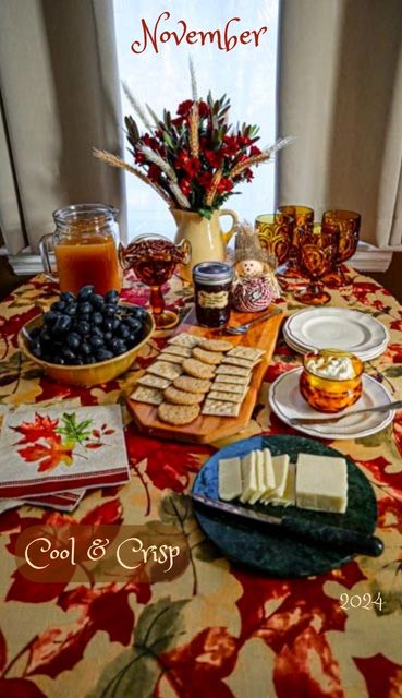 november dinner table setting with cheese and crackers jelly grapes and cider