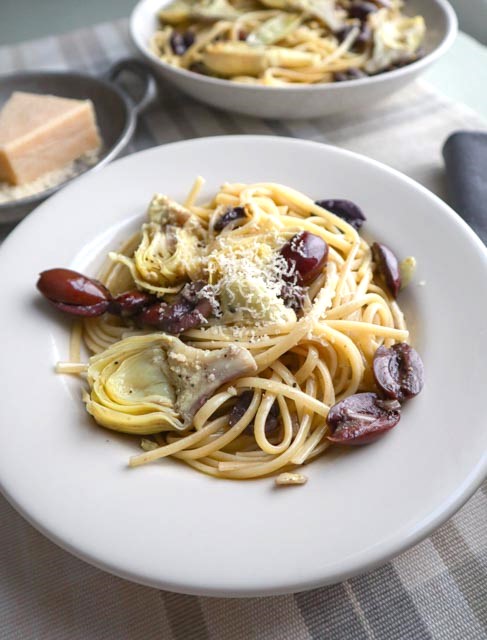 olive and artichoke pasta served with grated parmesan cheese